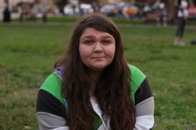 A young woman sitting in a city park.