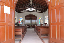 Church sanctuary with wooden pews and beams.