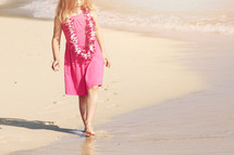 girl child wearing a Leis on a beach 