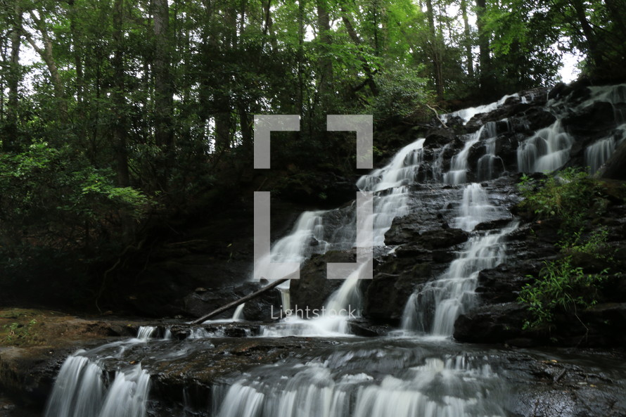 a cascading waterfall in a forest 