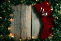 Christmas lights and pine garland frame with stocking 