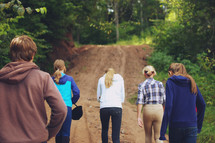 teens walking down a dirt road 