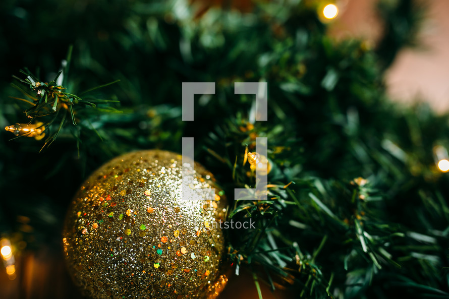 gold ornaments, pine garland, Christmas lights