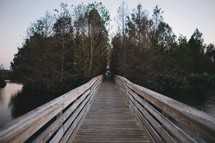 a wooden footbridge over water 
