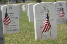 American flags in front of tombstones 