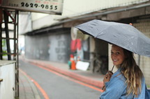a woman walking down the street carrying an umbrella 