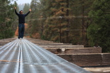 man standing on tracks with his arms raised in worship