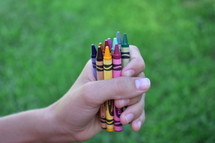 hands holding crayons 
