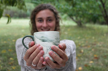 young woman holding a mug 