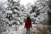 a woman standing in a forest in winter 