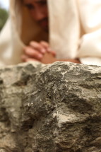 Jesus in prayer to God on a rock