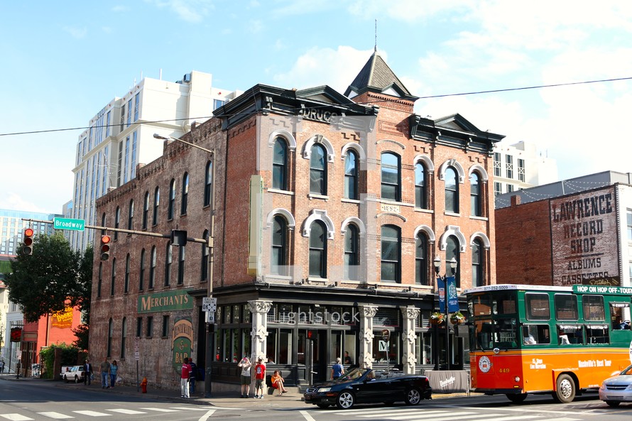 tour bus passing in front of an old brick building 