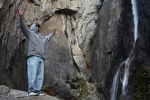 Man on mountain with raised hands