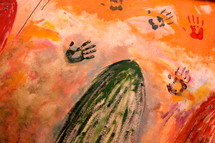 Mural with painted hand prints on orange color background