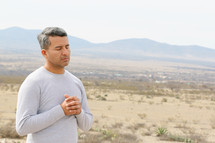 a man praying in a desert 
