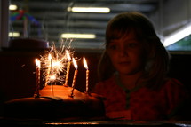 child and candles on a birthday cake 