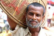 Bangladeshi man with a basket in the market. 