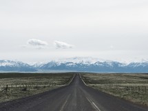 rural road and snow capped mountains 