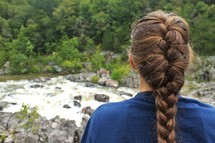 a woman watching river rapids 