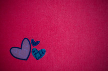 blue paper heart cut outs on red