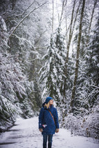 a woman standing in a winter forest 