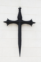 An iron cross on a white wall.