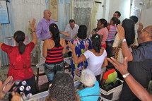 Hands raised in praise at a worship service in a small church in Havana, Cuba