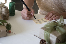 a woman writing on gift tags 