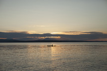 a man in a kayak at sunset 