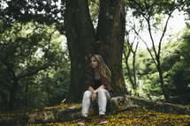 teen girl sitting under a tree 