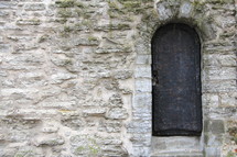 Arched door and doorway in an ancient stone wall 