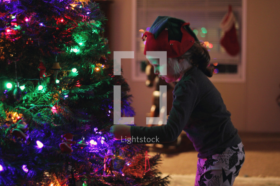 a girl decorating a Christmas tree 