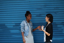 friends talking in front of a blue wall 