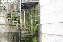 Winding outdoor staircase covered in moss