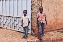 children leaning against the corner of a building exterior 
