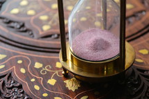 Sand running through an antique hour glass measuring time