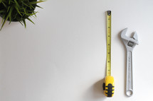 measuring tape, wrench, and house plant 