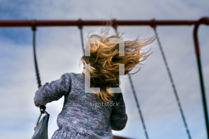 a child swinging on a swing set 