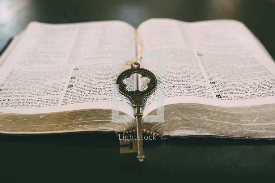 a key on the pages of a Bible 