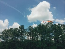 helicopter flying over a forest 