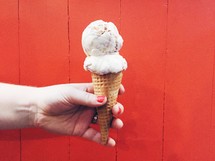 a hand holding an ice-cream cone 