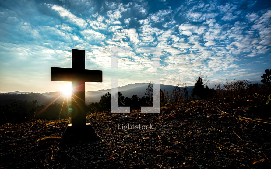 silhouette of a cross on a mountaintop 