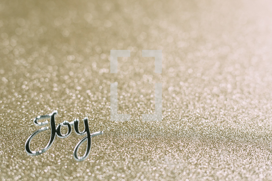 word joy on gold glittery background 
