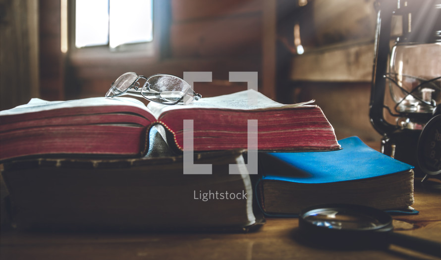 reading glasses and magnifying glass with Bibles 