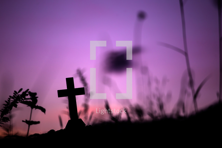 silhouette of a cross against a purple sky