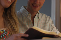 a young couple reading a Bible together 