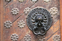 Lion door knocker on ancient wooden door