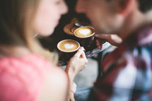 Couple drinking coffee with heart shaped foam
