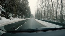 It is snowing in winter road, view from behind car window, slow motion

