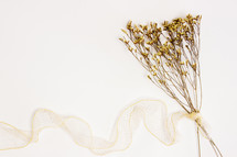 dried flowers with yellow ribbon on white 